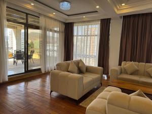 a living room with two chairs and a couch and a table at Beta Guesthouse in Addis Ababa