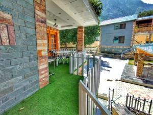 a patio with tables and chairs on a building at Walnut Nest Villa Kalam by Khan Familia Travels in Kalām
