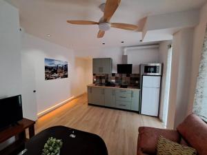 ein Wohnzimmer mit Deckenventilator und eine Küche in der Unterkunft Piso Jaén Parque in Jaén