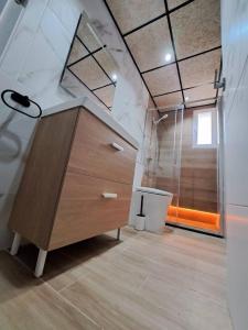 a bathroom with a wooden dresser and a shower at Piso Jaén Parque in Jaén