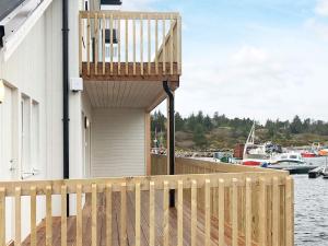 a balcony on the side of a building next to the water at 6 person holiday home in Kverva in Dyrvik