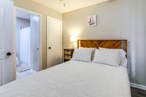 a bedroom with a white bed with a wooden headboard at Jacksonville Home By Camp Lejeune, Beaches and More! in Jacksonville
