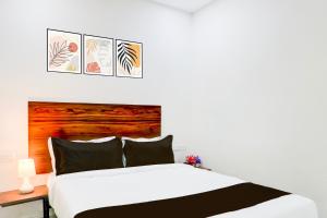 a bedroom with a white bed with three pictures on the wall at Super Collection O SS BLUE INN in Hyderabad +21 photos