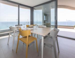 a dining room with a table and chairs and the ocean at Apartamento Infinium 4 - Costa CarpeDiem in Calpe +49 photos