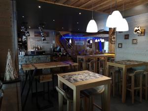 a bar with wooden tables and bar stools at "Alpages de Val Cenis"-Skis aux pieds-Spa-Wifi-Garage-Calme! in Lanslebourg-Mont-Cenis