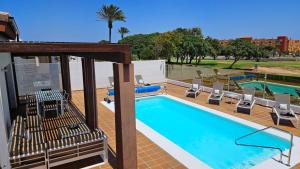 a swimming pool with lounge chairs and a pool at Villa BELLA on Golf in La Estancia, Caleta Fuste-Fuerteventura in Caleta De Fuste