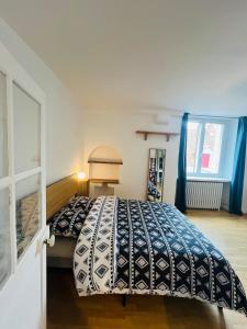 a bedroom with a bed with a blue and white comforter at maison cosy avec jardin in Suèvres