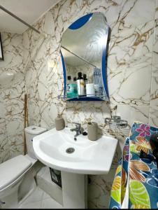a bathroom with a sink and a mirror and a toilet at Cosy Studio in Tangier