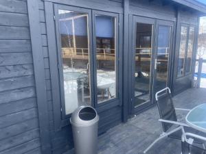a screened porch with glass doors and a trash can at Lapland cabin in Kilpisjärvi
