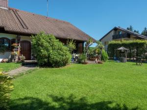 a house with a yard with green grass at Ferienwohnung in Gütenbach in Furtwangen