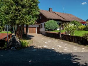a house with a tree and a driveway at Ferienwohnung in Gütenbach in Furtwangen +32 photos