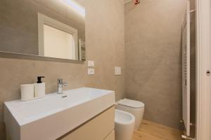 a bathroom with a white sink and a toilet at Alpine Escape 1BR Apartment A in Tarvisio