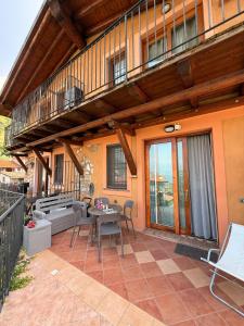 a patio with a table and chairs and a balcony at Matteo Lago in Sale Marasino