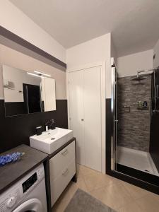 a bathroom with a sink and a shower and a washing machine at Matteo Lago in Sale Marasino +37 photos