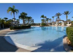 a large swimming pool with palm trees in a resort at 3 Bedroom Condo with Water Park & Fantastic Pool only Minutes To Walt Disney World's Front Gate!!! in Orlando