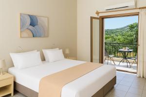 a bedroom with a bed and a balcony at Artemida Pansion Georgioupolis in Kournás