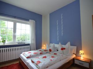 a bedroom with a large bed with red flowers on it at Charming Forest Escape for Two in Langewiesen