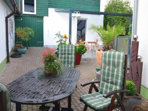 a patio with a table and two chairs and flowers at Charming Forest Escape for Two in Langewiesen