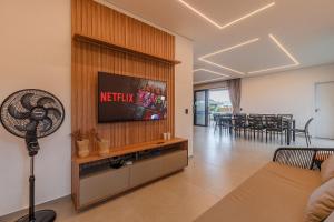 a living room with a flat screen tv on a wall at Summerville #269 - Casa em Cumbuco by Carpediem in Caucaia