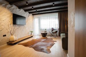 a living room with a couch and a tv at Avalanche Chalet in Poiana Brasov