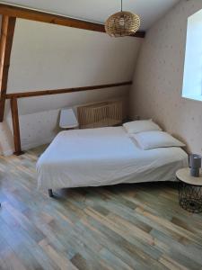 a bedroom with a white bed and a wooden floor at Chez Monique - Mur de Sologne - 8 personnes in Mur-de-Sologne +13 photos