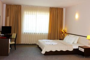 a hotel room with a bed and a window at Kendros Hotel in Plovdiv
