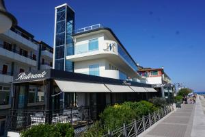 ein weißes Gebäude mit einer Markise davor in der Unterkunft Hotel Negretto in Caorle