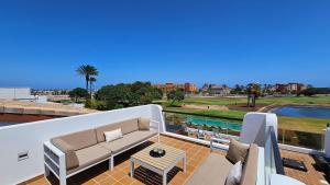a balcony with a couch and a table at Villa BELLA on Golf in La Estancia, Caleta Fuste-Fuerteventura in Caleta De Fuste