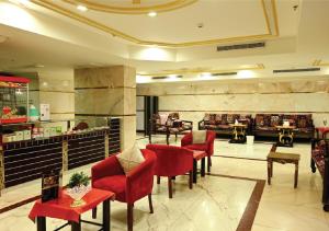 a lobby of a hotel with red chairs and tables at فندق هيلا ان للايواء السياحي Hailaann Hotel in Al Khansāk