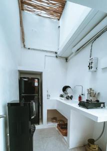 cocina con paredes blancas y nevera negra en Chic Suda 2 Villa Sanur, en Sanur