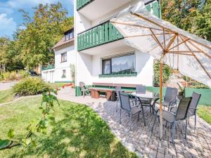 a patio with a table and chairs and an umbrella at Geräumiges Apartment am Waldrand im Sauerland in Medebach