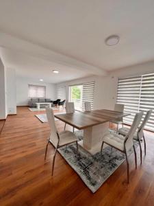 ein Esszimmer mit einem Holztisch und Stühlen in der Unterkunft River Prestige Resort Villa1 in Ilijaš