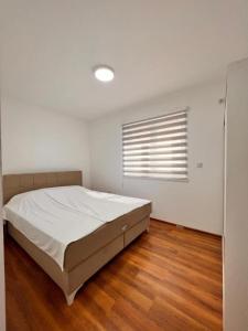 ein weißes Schlafzimmer mit einem Bett und einem Fenster in der Unterkunft River Prestige Resort Villa1 in Ilijaš