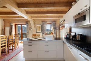 a kitchen with white cabinets and wooden ceilings at Maison de village Puyvalador in Puyvalador +22 photos
