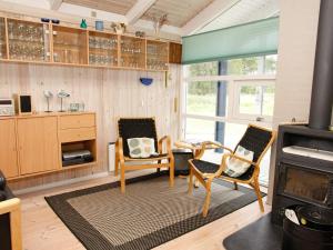 a living room with two chairs and a stove at Secluded Oasis with Pool - By Traum Ferienwohnungen in Skram