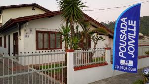 a house with a sign in front of it at Pousada Joinville in Joinville