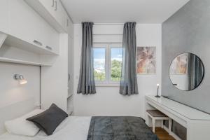 Schlafzimmer mit einem Bett, einem Spiegel und einem Schreibtisch in der Unterkunft Villa Zlatne NiTi with heated pool in Kaštela + 75 Fotos