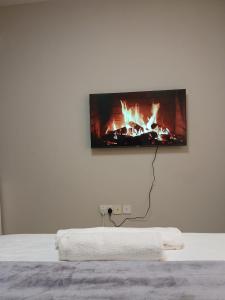 a flat screen tv hanging on a white wall at Staunch Homes Luxury Studio Apartment in Nairobi +5 photos
