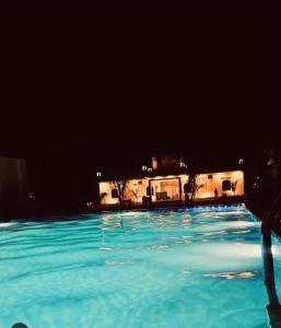 a swimming pool at night with a house in the background at Apex resort in Pushkar