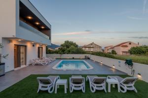Villa mit Pool und Stühlen in der Unterkunft Villa Zlatne NiTi with heated pool in Kaštela