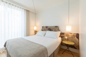 a bedroom with a large bed and a window at Chic 1-BR Flat in Award-Winning Building in Bicas