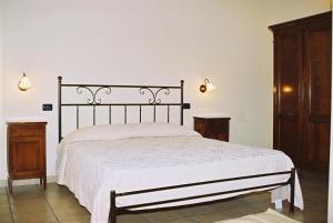 1 dormitorio con 1 cama con colcha blanca en Agriturismo SaTanca, en Arbus