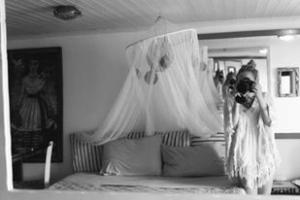 une femme debout à côté d'un lit à baldaquin dans l'établissement Studio Paradiso, à Plaka Milou