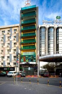 a large building with cars parked in front of it at City Point Hotel in Manama