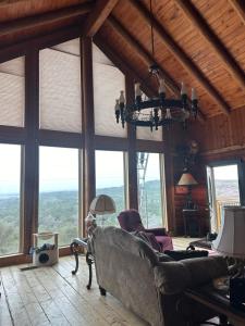 a living room with a couch and large windows at The Walpole Cabin in Mico