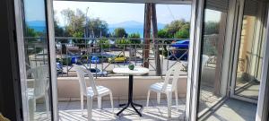 a balcony with a table and chairs and a view of a marina at Coralli Loft in Nea Anchialos