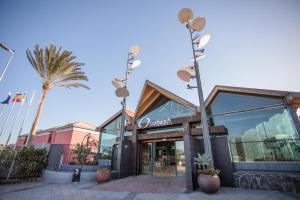 a building with a palm tree in front of it at Caybeach Meloneras in Meloneras +52 photos