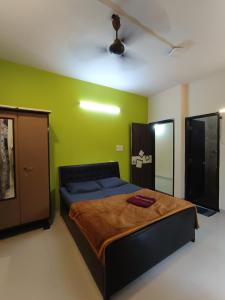 ロナバラにあるPlanet C villa - 3 BHK with private swimming poolのベッドと緑の壁のある寝室