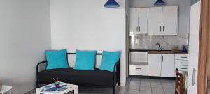 a living room with a couch with blue pillows at Casa Blu Loft in Nea Anchialos