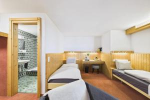 a room with two beds and a desk in it at Central suite to stay for 2 experience Saas-Fee in Saas-Fee +8 photos